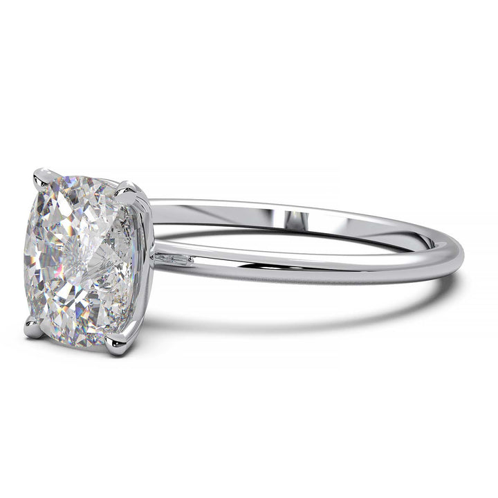 Gold engagement ring featuring a cushion-cut diamond in a four-prong setting.