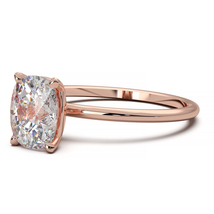 Gold engagement ring featuring a cushion-cut diamond in a four-prong setting.