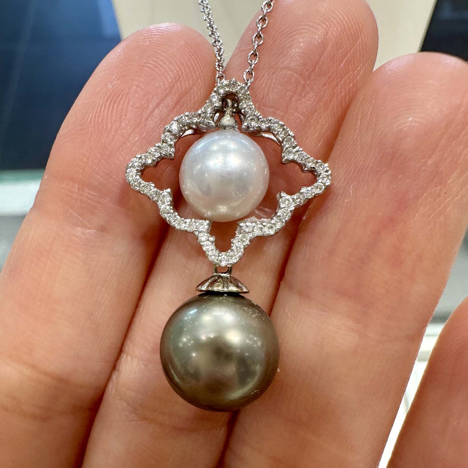 Dual pearl pendant with a light green 10.6mm Tahitian pearl and an 8.5mm white South Sea pearl set in 18K white gold with natural diamonds.