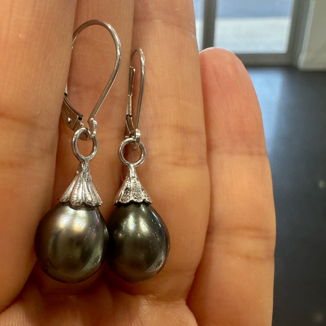 A pair of Tahitian dark green drop-shaped pearl earrings with small diamonds on 14K white gold.