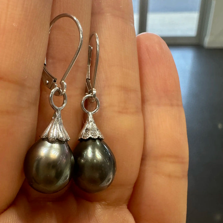 A pair of Tahitian dark green drop-shaped pearl earrings with small diamonds on 14K white gold.