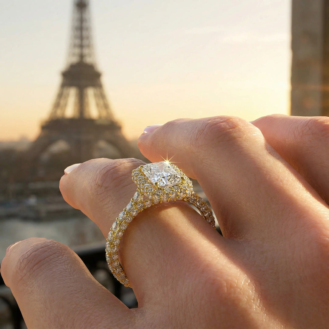 Emerald-cut diamond halo engagement ring with triple prong-set diamond band shown in display view.