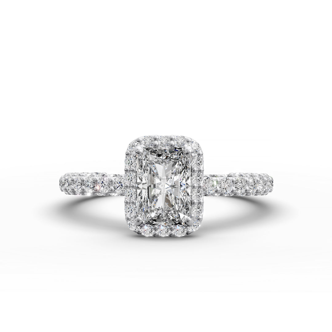 Emerald-cut diamond halo engagement ring with triple prong-set diamond band shown in display view.