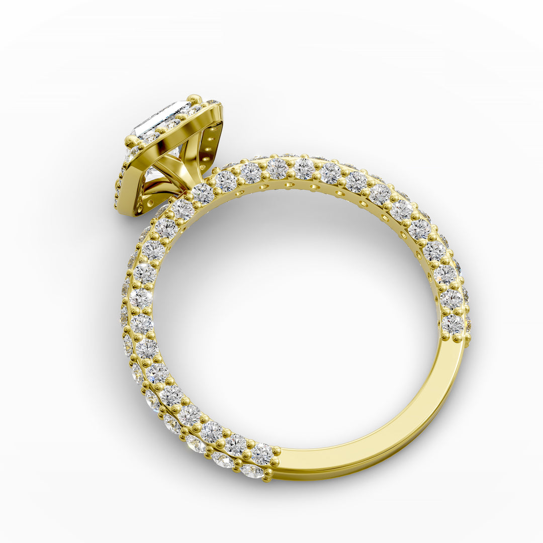 Emerald-cut diamond halo engagement ring with triple prong-set diamond band shown in display view.