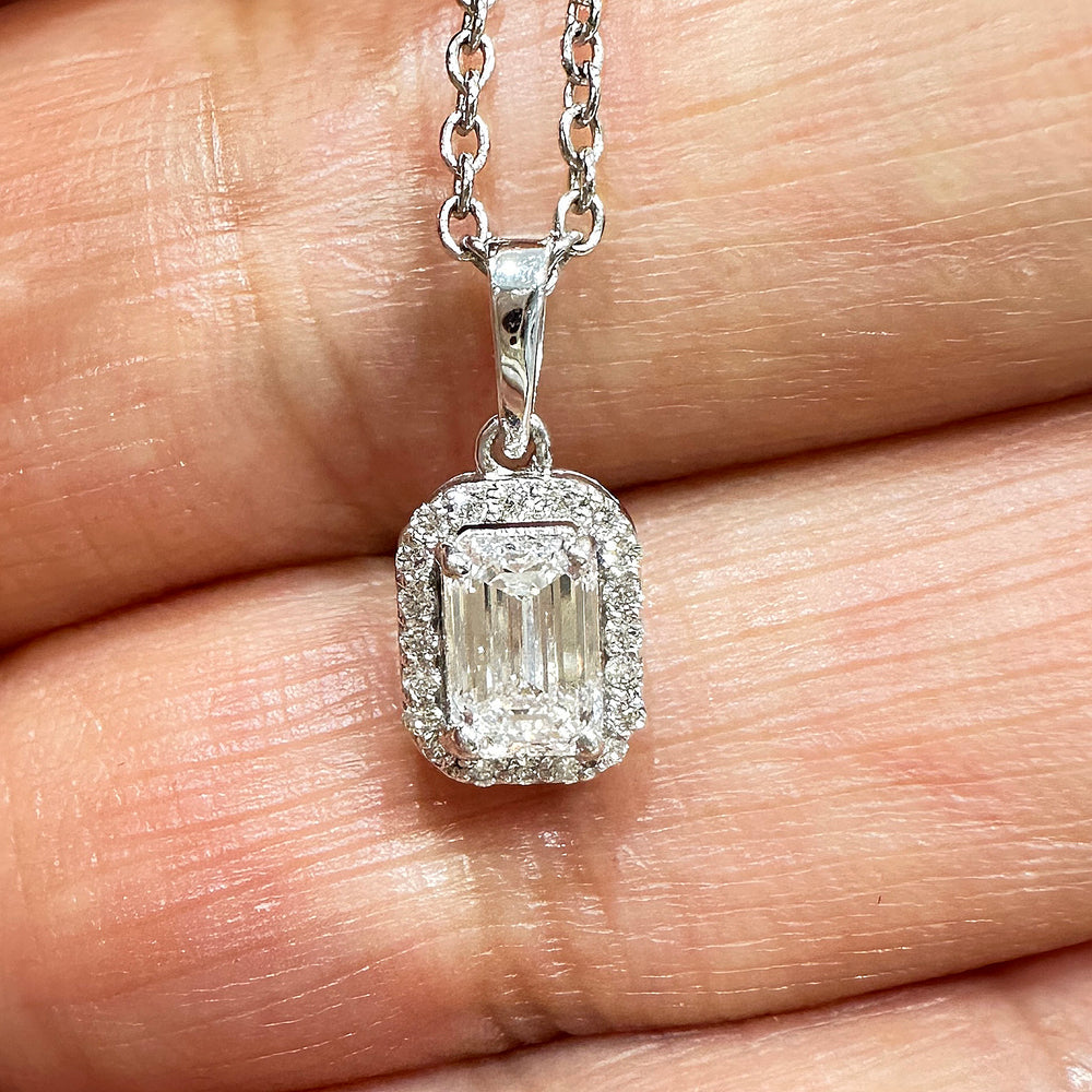 Close-up of a 10K white gold pendant featuring a 0.50ct emerald-cut lab diamond with a halo of smaller diamonds.
