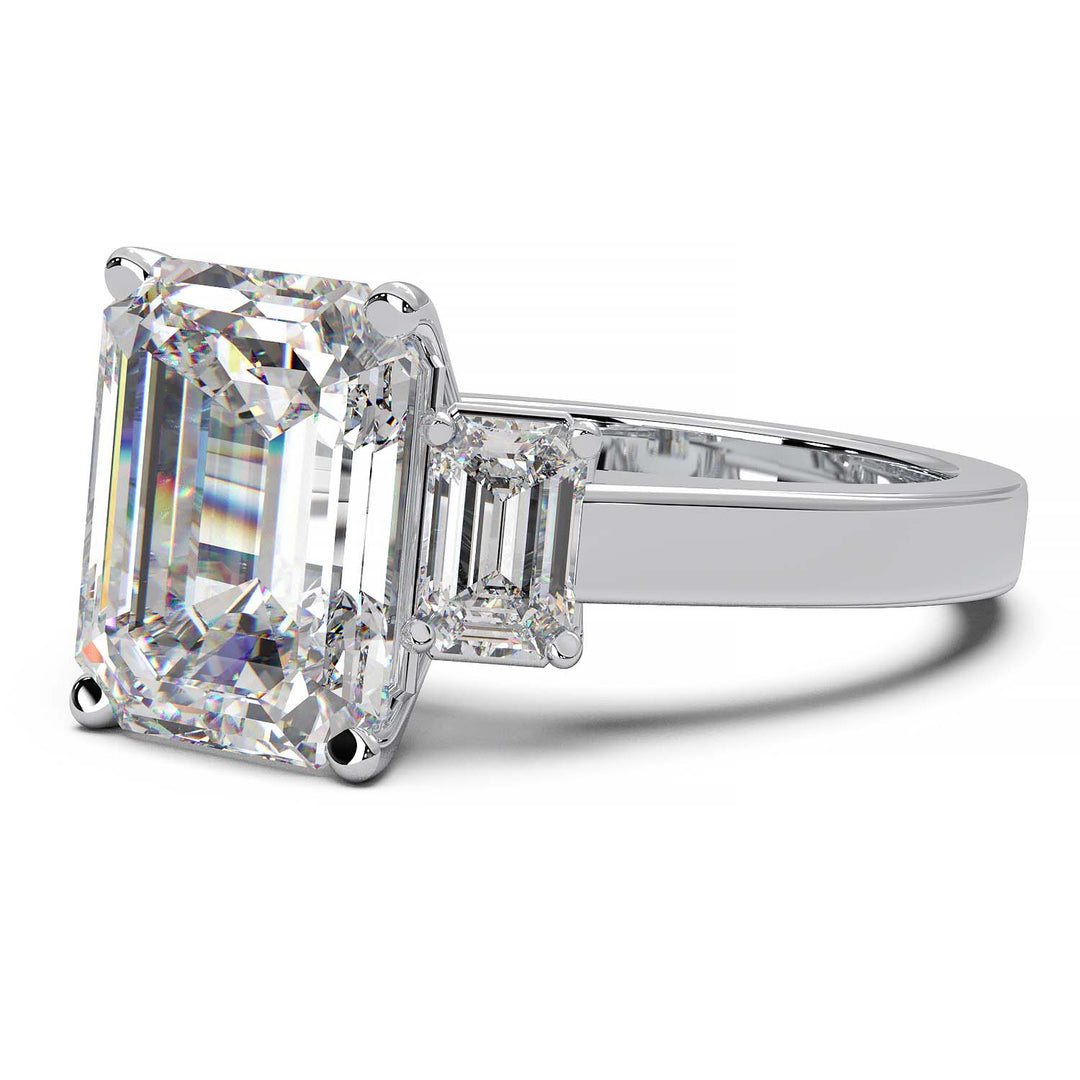 Three-stone engagement ring with 3.5 carat emerald cut lab-grown diamond center and emerald cut side stones.