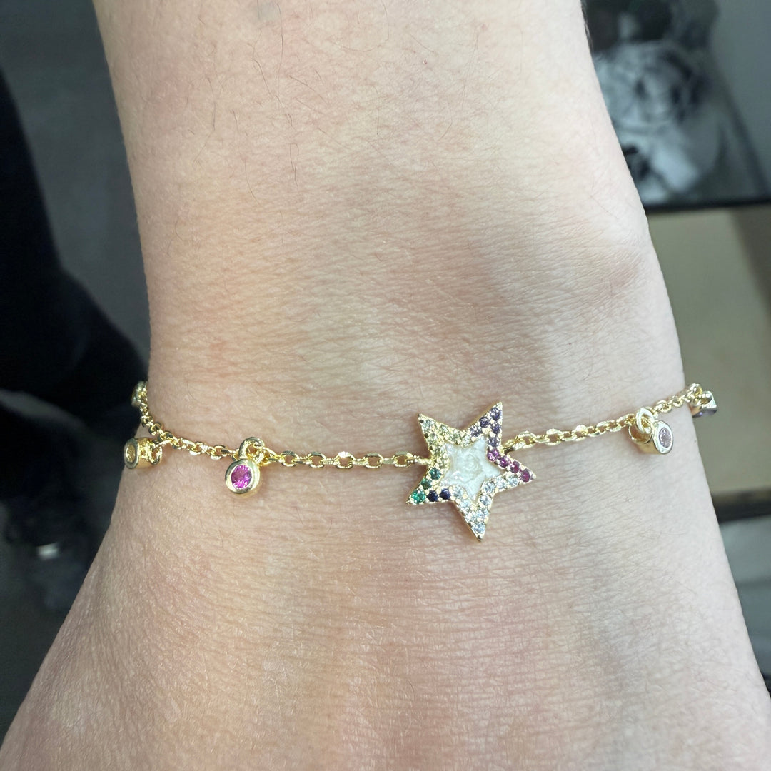 Silver star charm cubic zirconia bracelet worn on wrist.
