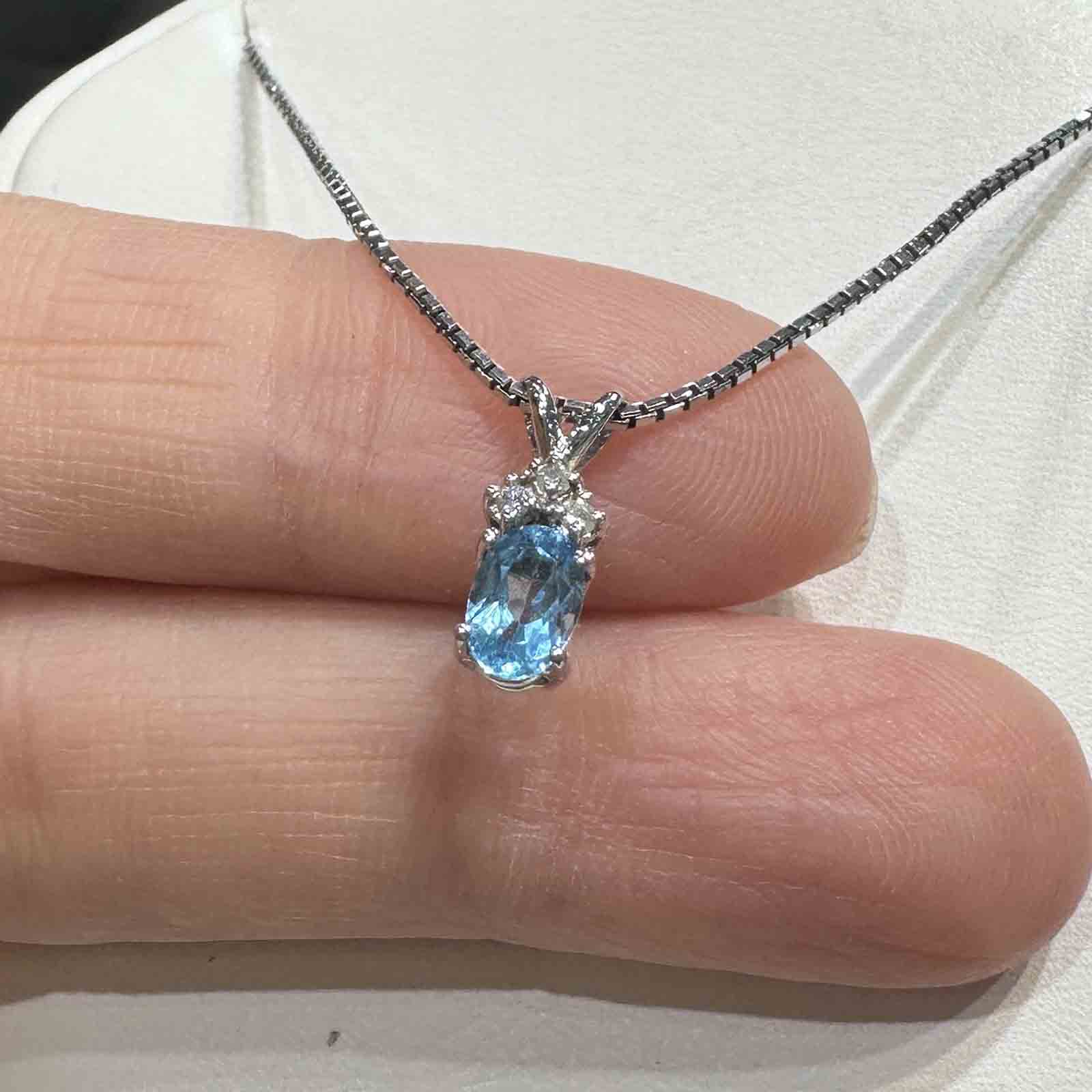 14K white gold pendant with genuine blue topaz and natural diamond accent, perfect for December birthstone gifts.