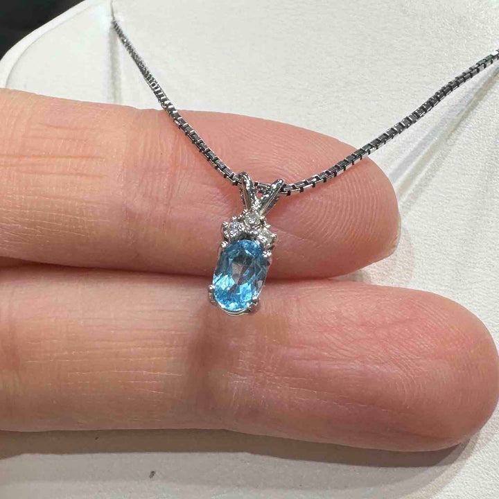 14K white gold pendant with genuine blue topaz and natural diamond accent, perfect for December birthstone gifts.