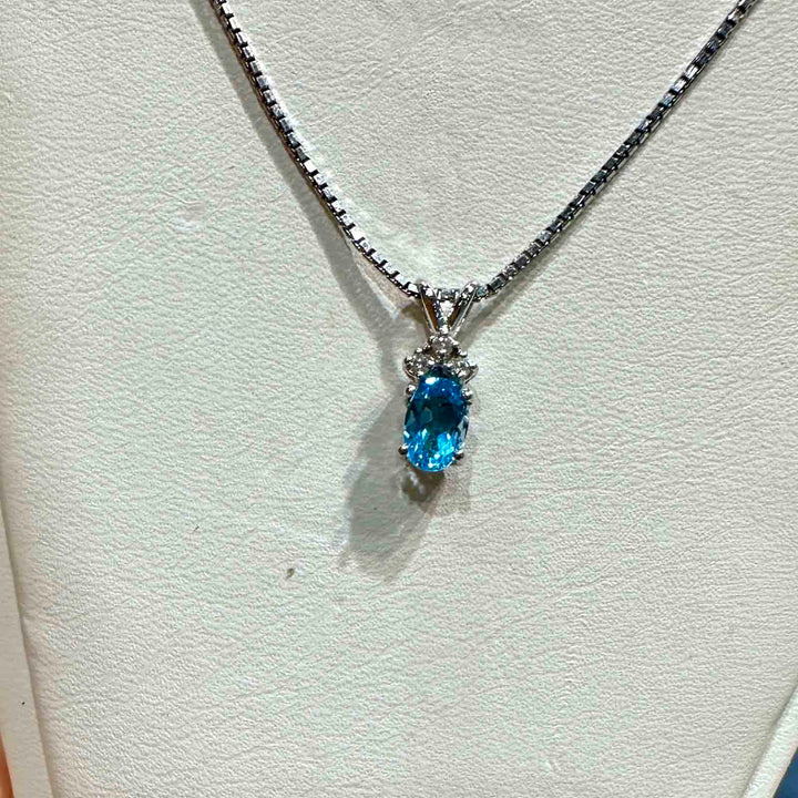 14K white gold pendant with genuine blue topaz and natural diamond accent, perfect for December birthstone gifts.