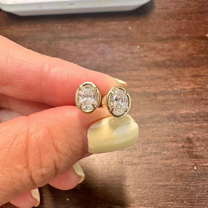 Certified oval-shaped lab grown diamond stud earrings in yellow gold bezel setting