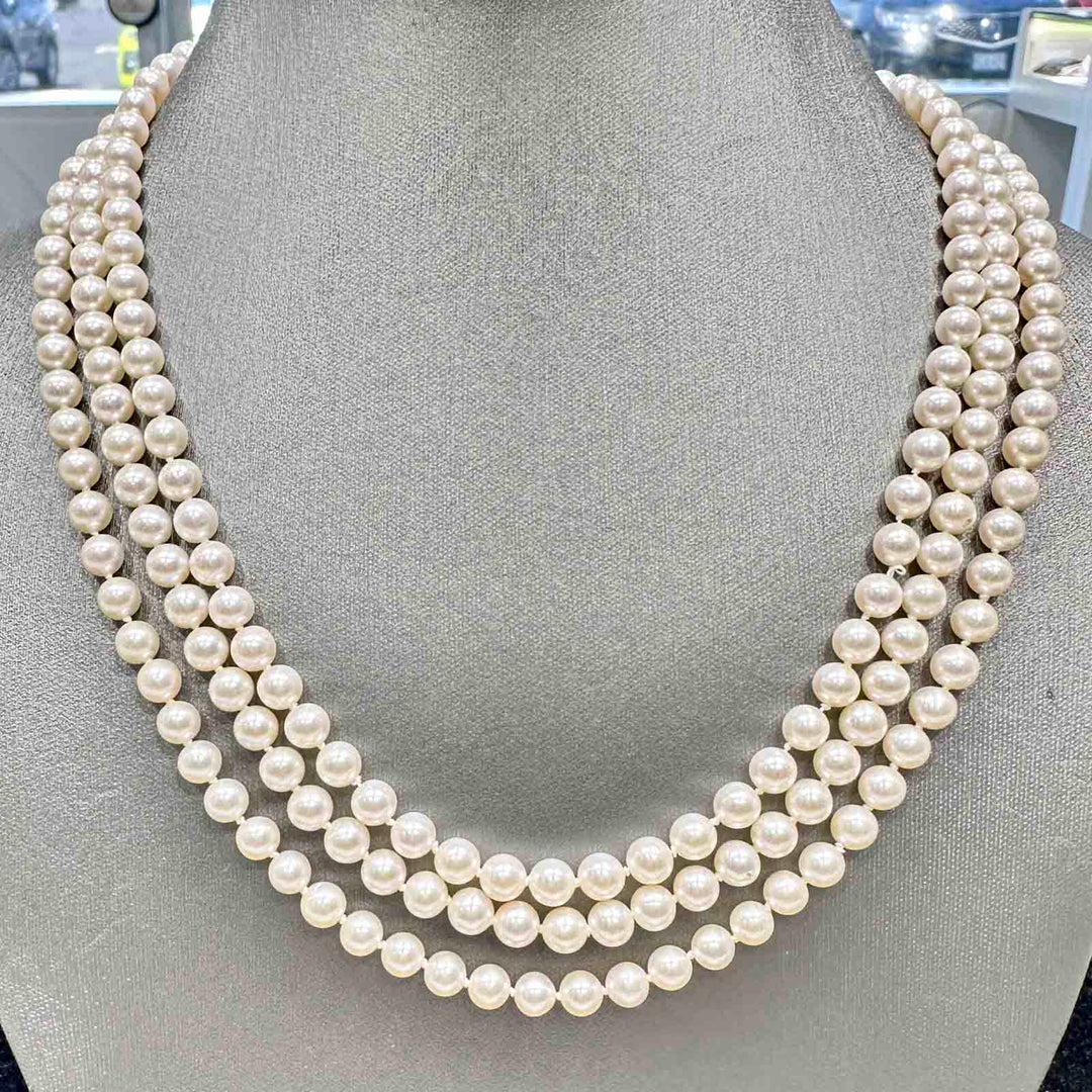 Three-strand freshwater pearl necklace with 6-5.4mm high luster white pearls and a 14k yellow gold clasp.