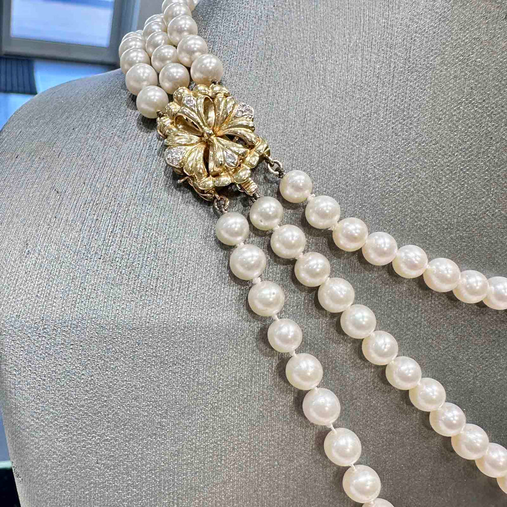 Three-strand freshwater pearl necklace with 6-5.4mm high luster white pearls and a 14k yellow gold clasp.