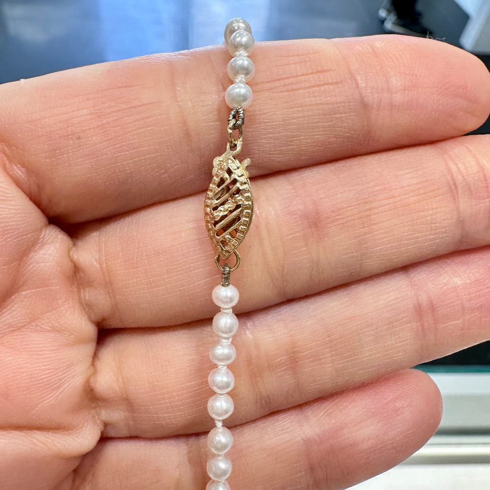 Delicate freshwater pearl necklace with 3.1mm round white pearls, 21 inches long, featuring a 14k yellow gold fish clasp.