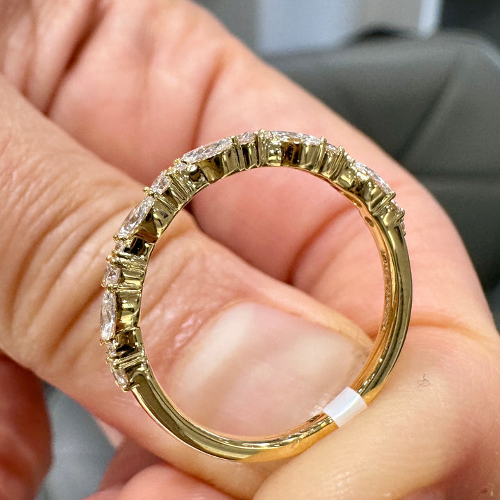 Close-up of a 14K yellow gold wedding band with lab-grown diamonds in unique settings.