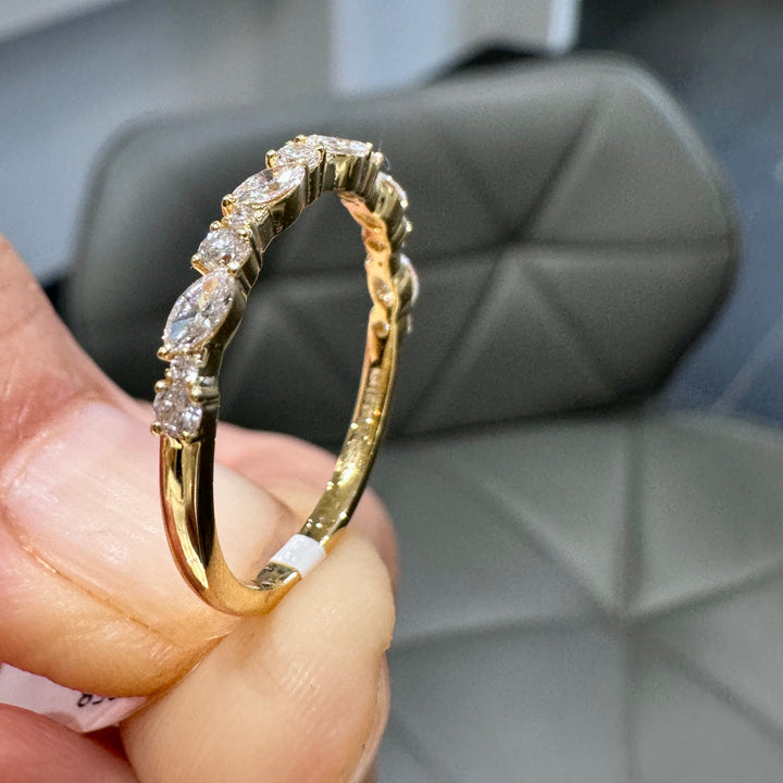 Close-up of a 14K yellow gold wedding band with lab-grown diamonds in unique settings.