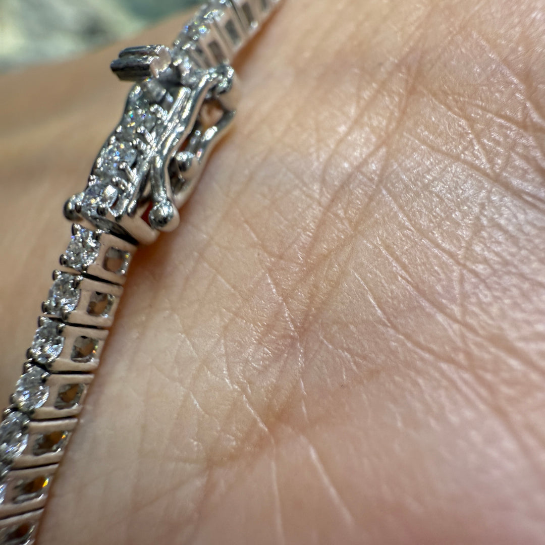 Close-up of a 14K white gold lab-grown diamond tennis bracelet with a four-prong, open-back basket-style setting, featuring 100 diamonds totaling 1.89 CT.
