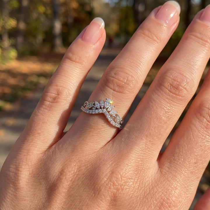 Marquise-style curved lab-grown diamond wedding band with round accent stones on display.