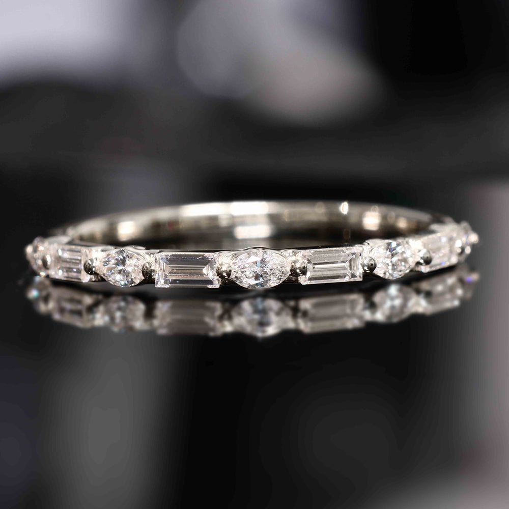 A wedding band with lab-grown marquise and baguette diamonds set with shared prongs, floating elegantly on the band.