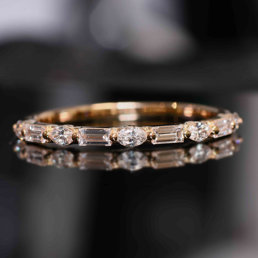 A wedding band with lab-grown marquise and baguette diamonds set with shared prongs, floating elegantly on the band.