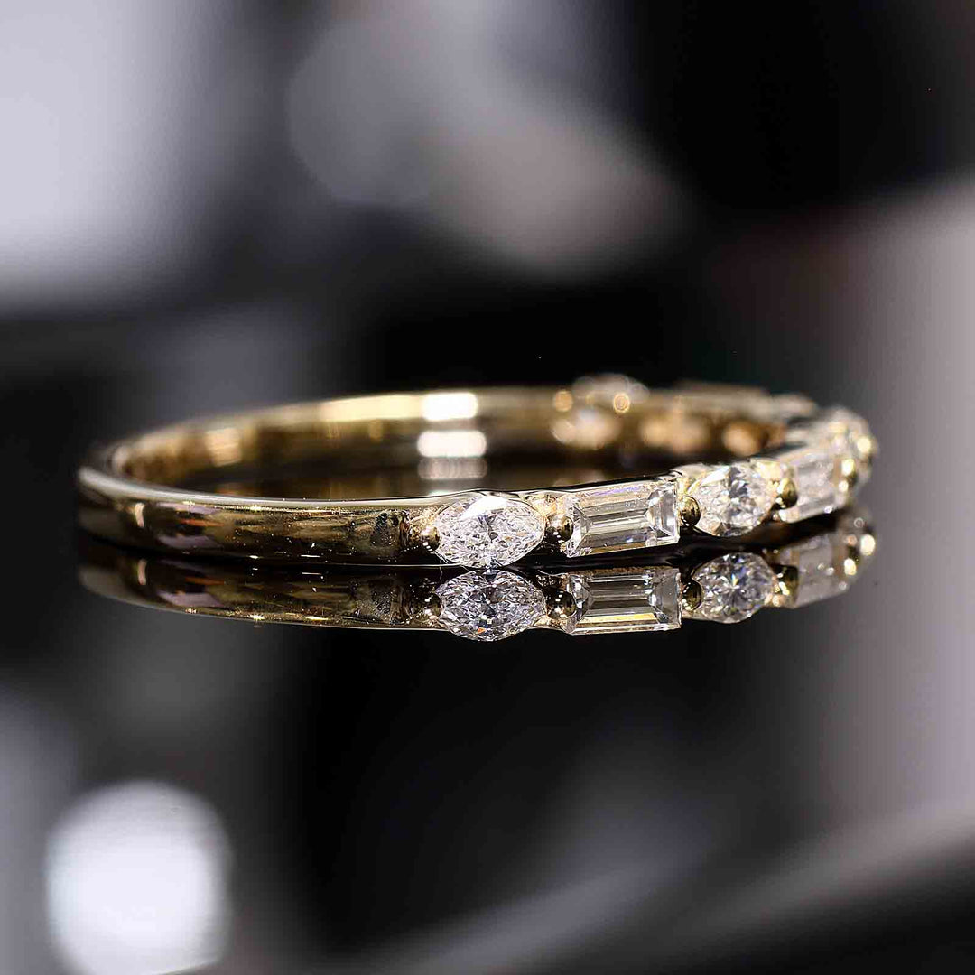 A wedding band with lab-grown marquise and baguette diamonds set with shared prongs, floating elegantly on the band.