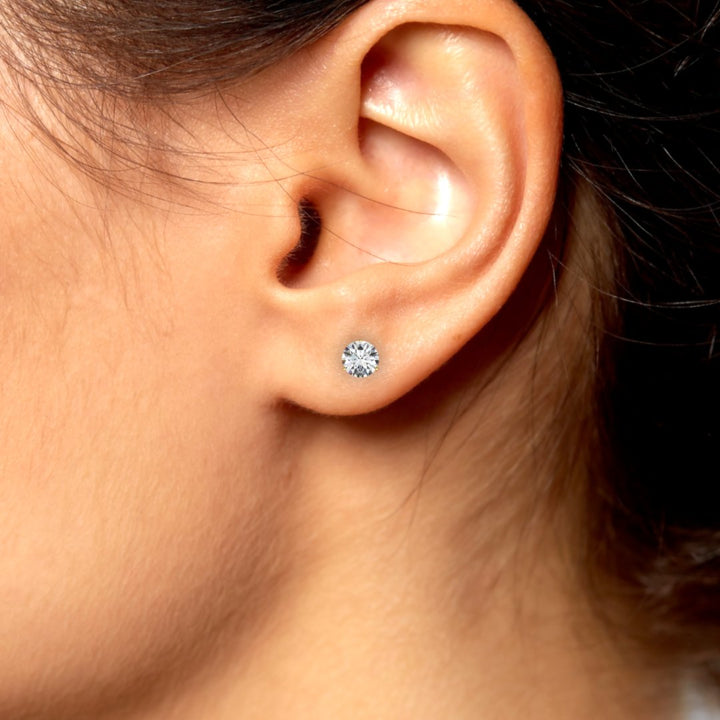 1 carat round lab-grown diamond martini stud earrings with three-prong setting.