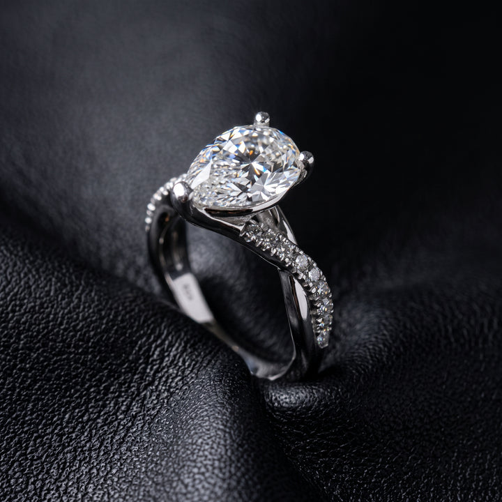 Moissanite pear-shaped engagement ring with 1.20CT center stone, accent moissanite, set in 14K gold.