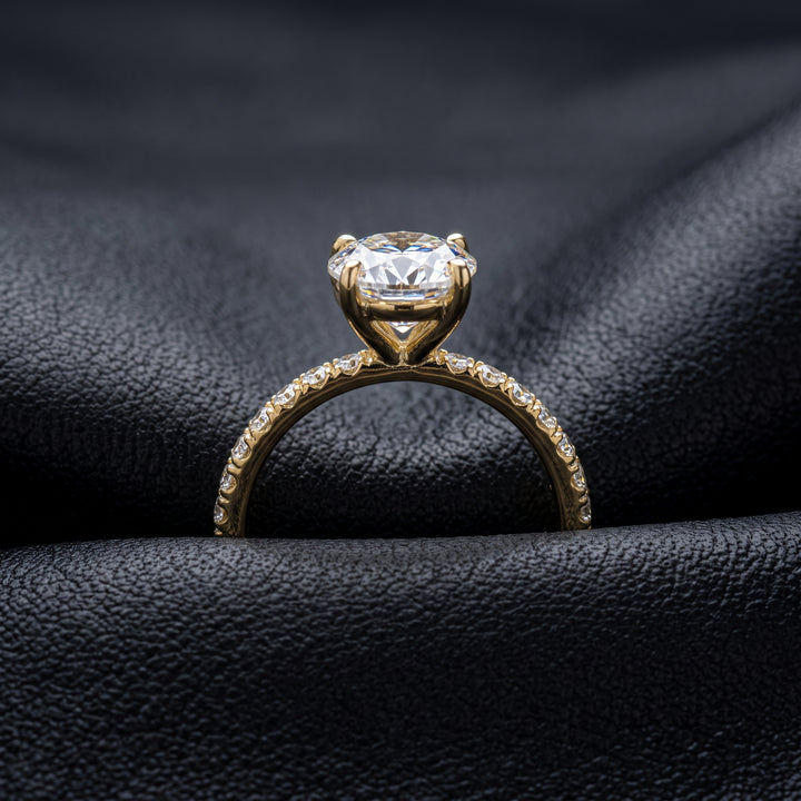 2.5 Ct oval moissanite engagement ring with pave band in 14K gold.