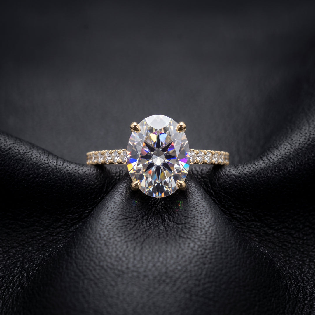 2.5 Ct oval moissanite engagement ring with pave band in 14K gold.