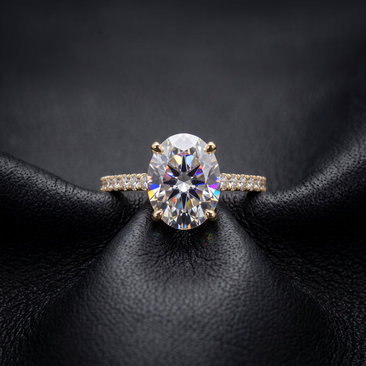 2.5 Ct oval moissanite engagement ring with pave band in 14K gold.