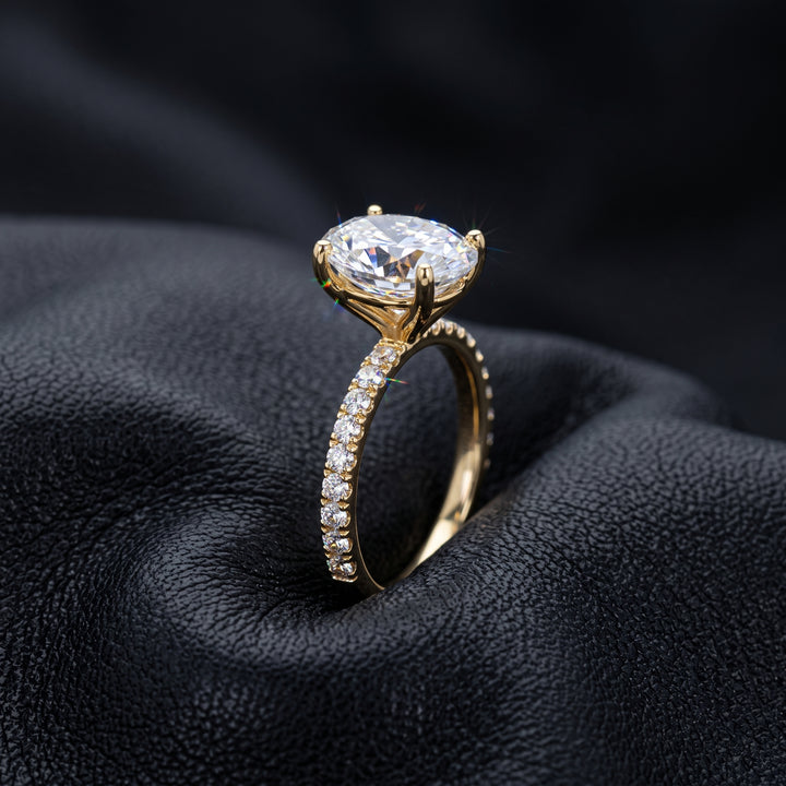 2.5 Ct oval moissanite engagement ring with pave band in 14K gold.