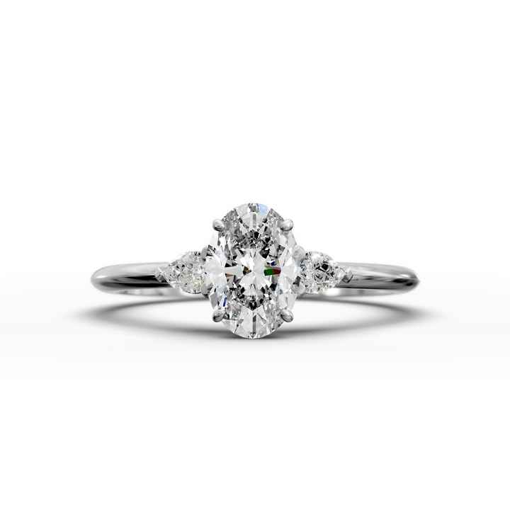 Oval three stone engagement ring with pear side diamonds on a slim band.