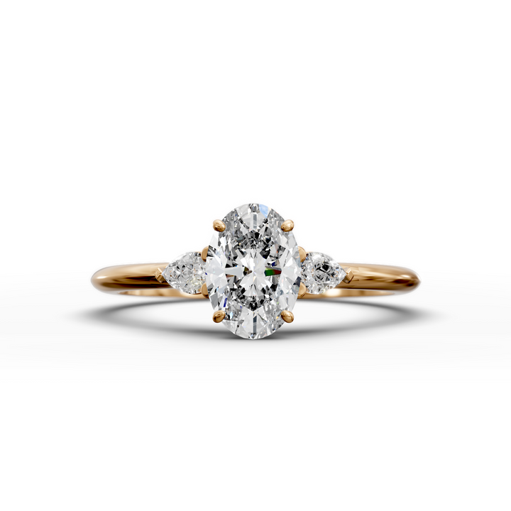 Oval three stone engagement ring with pear side diamonds on a slim band.