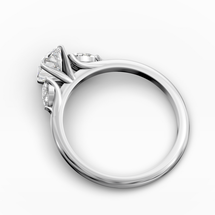 Oval three stone engagement ring with pear side diamonds on a slim band.