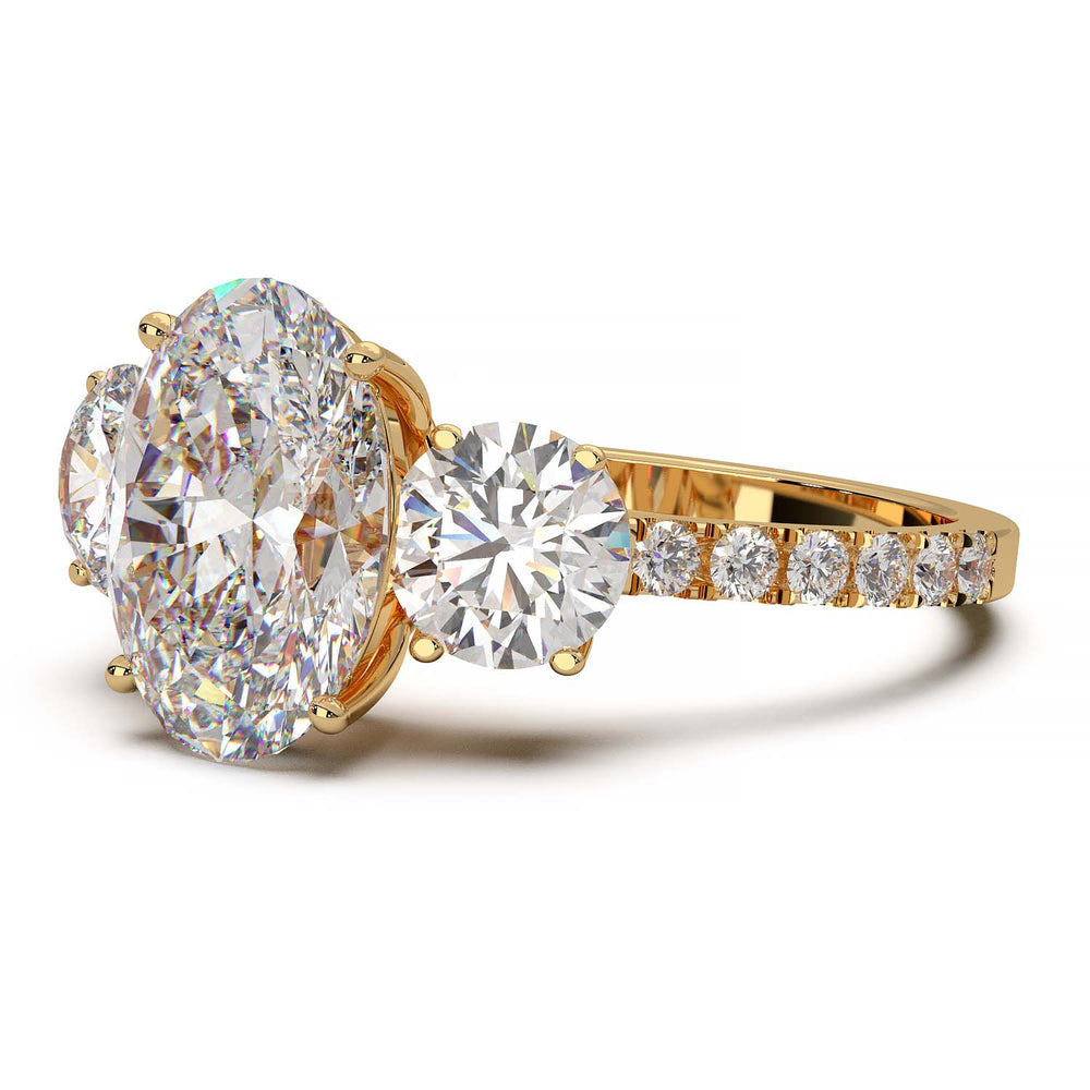 Three-stone engagement ring with 2-carat oval lab-grown diamond, round side stones, and pave band