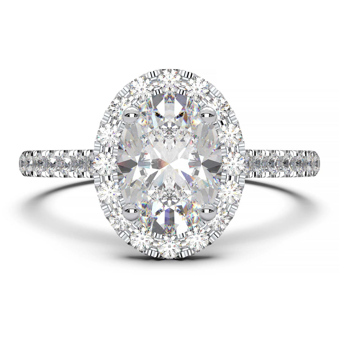 Oval lab-grown diamond halo engagement ring with pavé diamonds on the band in a cathedral setting.