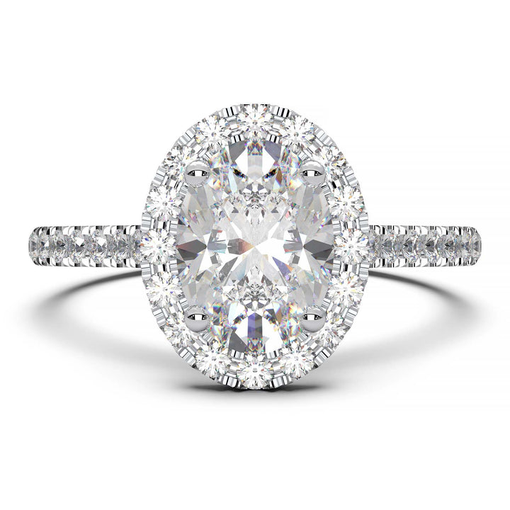 Oval lab-grown diamond halo engagement ring with pavé diamonds on the band in a cathedral setting.