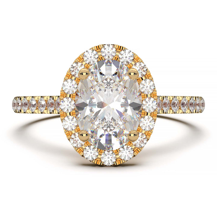 Oval lab-grown diamond halo engagement ring with pavé diamonds on the band in a cathedral setting.