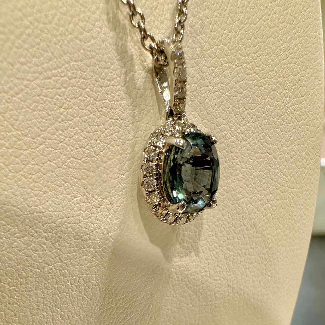 Oval blue sapphire pendant with diamond halo in 14k white gold, 1.60ct with light greenish overtone.