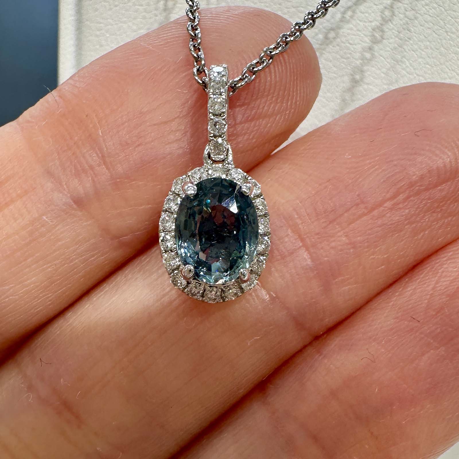 Oval blue sapphire pendant with diamond halo in 14k white gold, 1.60ct with light greenish overtone.