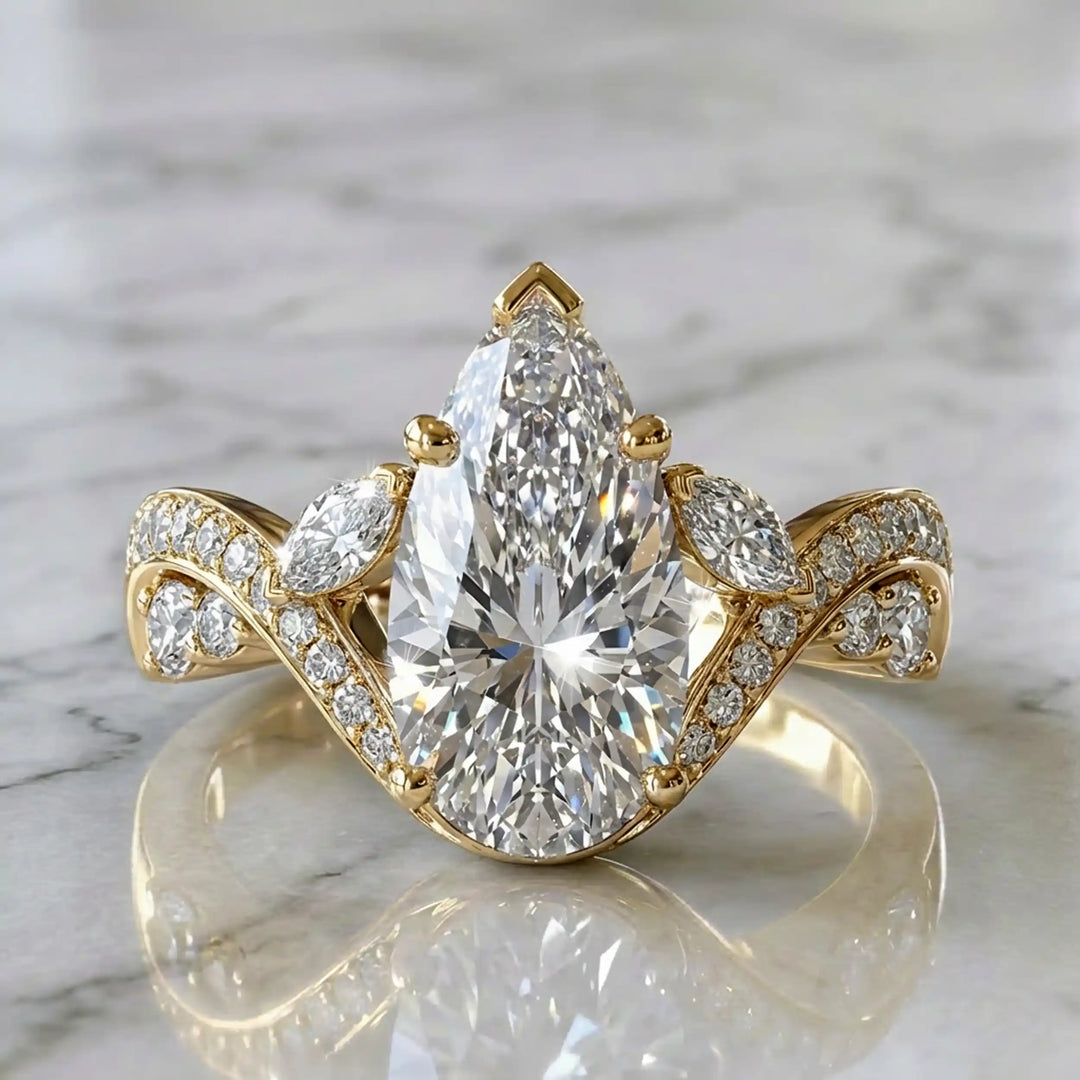 3 carat pear lab diamond twisted three-stone engagement ring displayed on marble surface.
