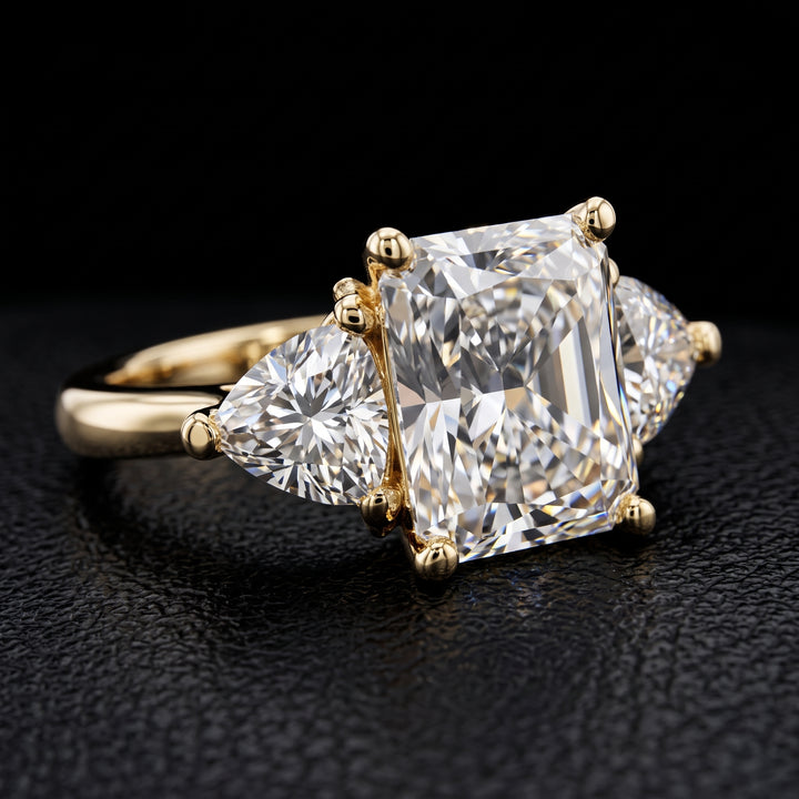 Radiant-cut moissanite ring with trillion side stones set in 14K yellow gold.