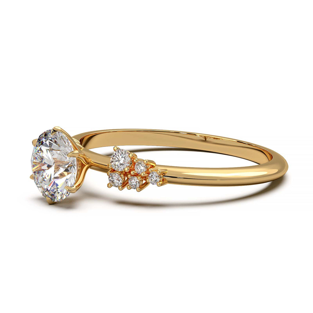 Dainty engagement ring with 0.7 carat round lab-grown diamond in a cluster setting, featuring side diamonds.