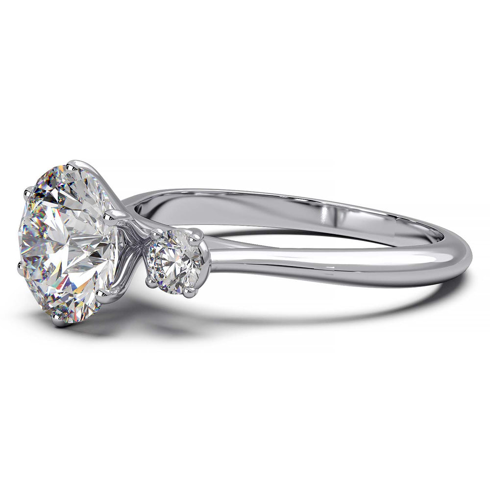 Three-stone engagement ring with 1.5 carat center diamond and two accent stones.