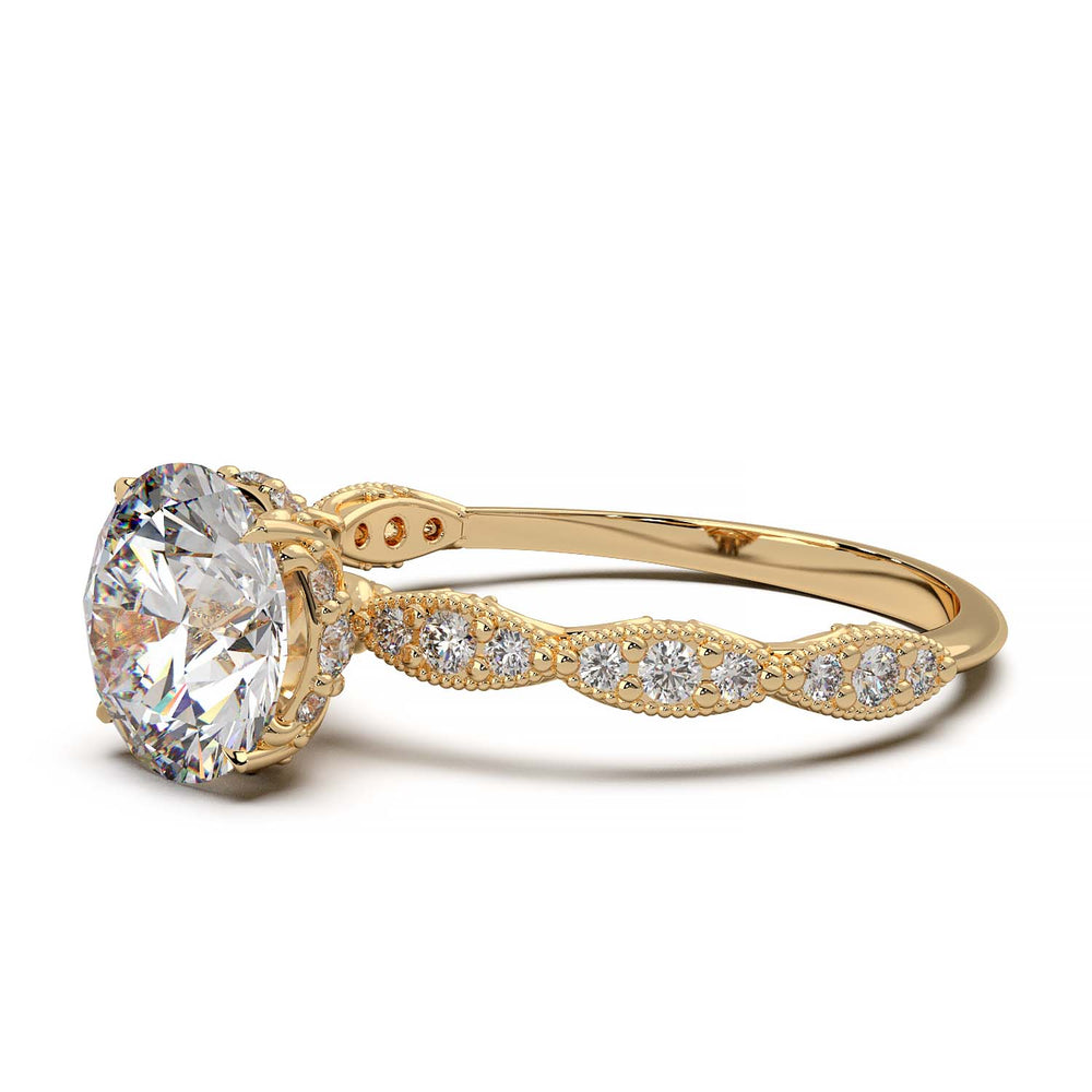 A vintage-style engagement ring featuring a large, round-cut diamond set in a gold band. The band is intricately detailed with smaller diamonds embedded in an ornate, floral and milgrain pattern, adding elegance and sparkle.