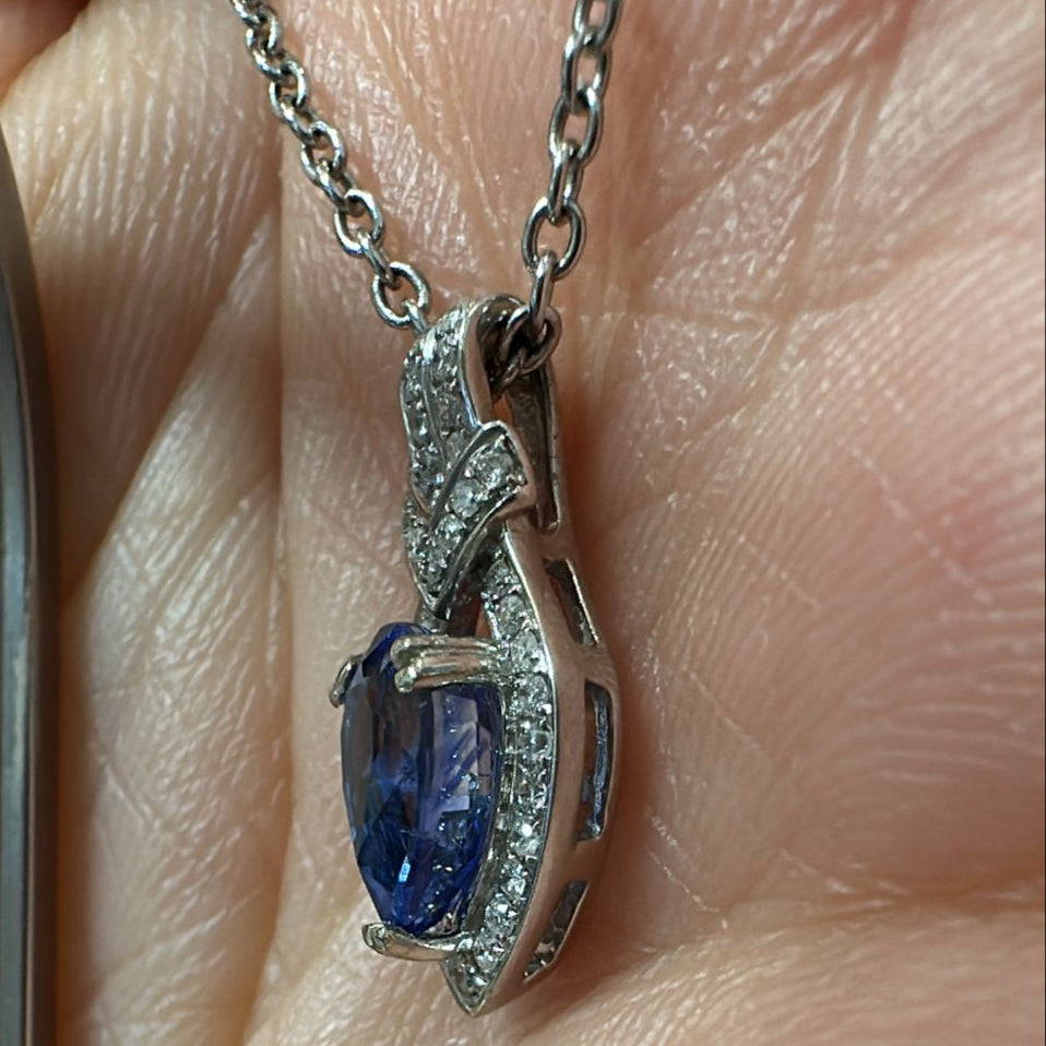 Pear-cut blue sapphire pendant with diamond halo in 14K white gold.