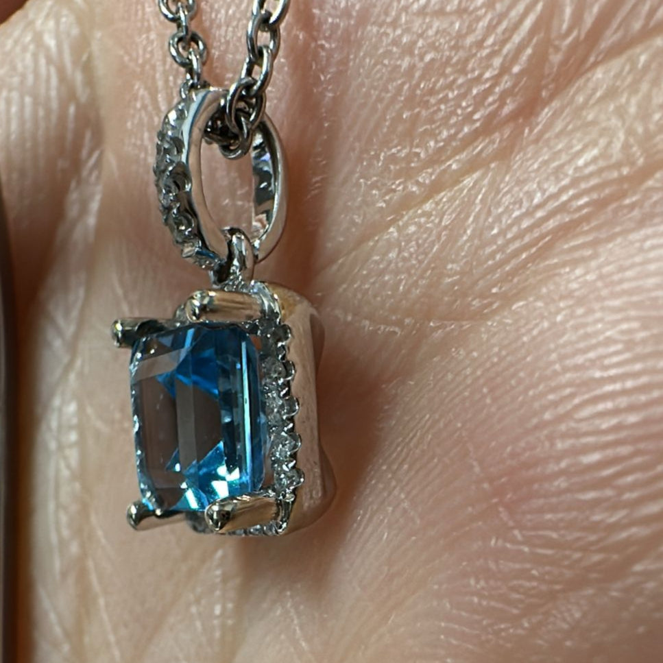 Princess-cut blue topaz pendant with diamond halo in 14K white gold.