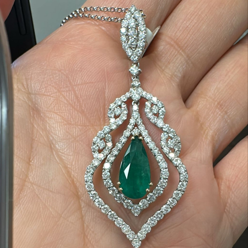 Pear-cut Colombian emerald pendant with ornate diamond halo in 18K white gold.