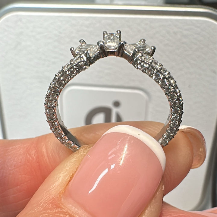 14K white gold moissanite wedding band with baguette and pavé-set stones in a curved design.