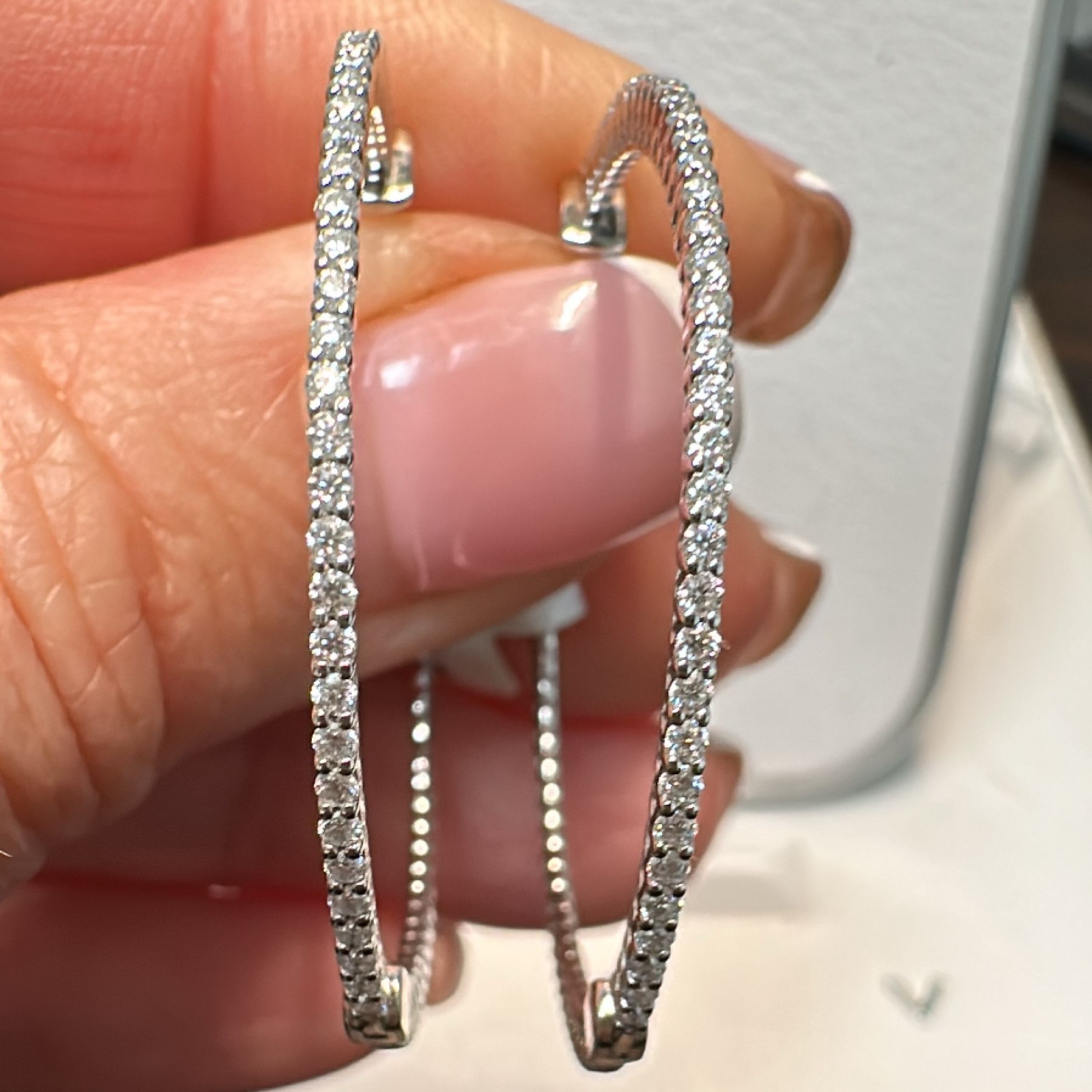 34mm moissanite hoop earrings in 14K white gold with a secure lock closure.